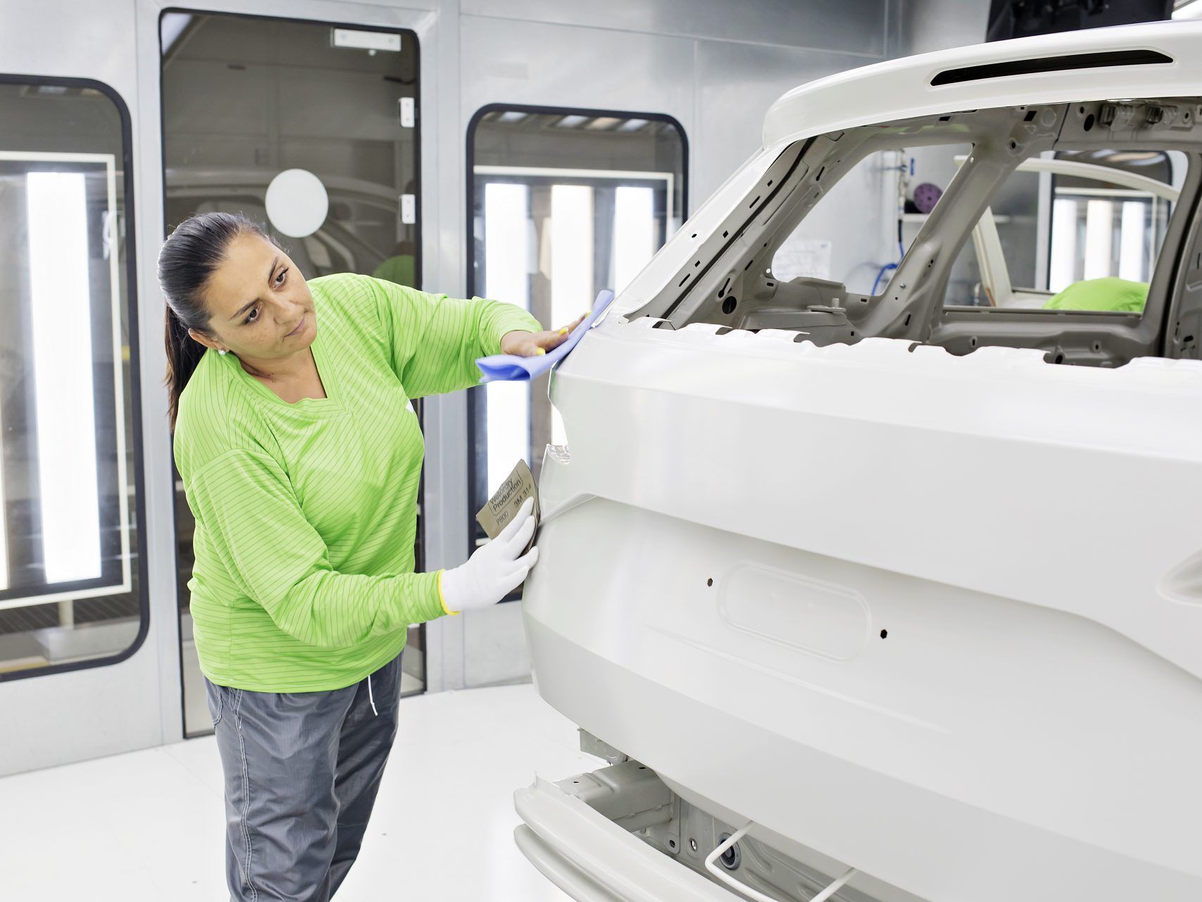 Skoda team member sanding the surface of the car to prep for paint coat