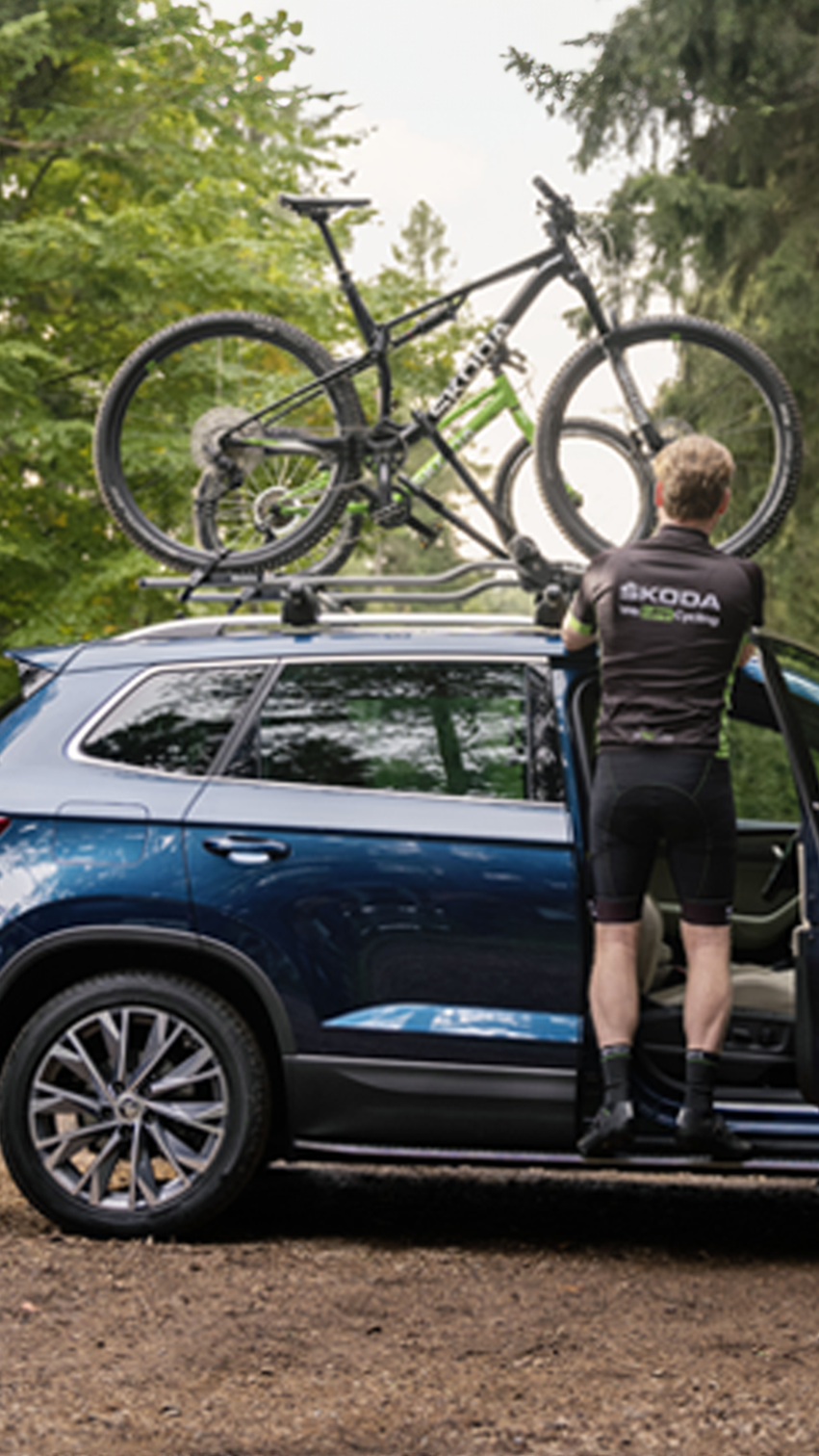 A guy mounting his bike on a Skoda car