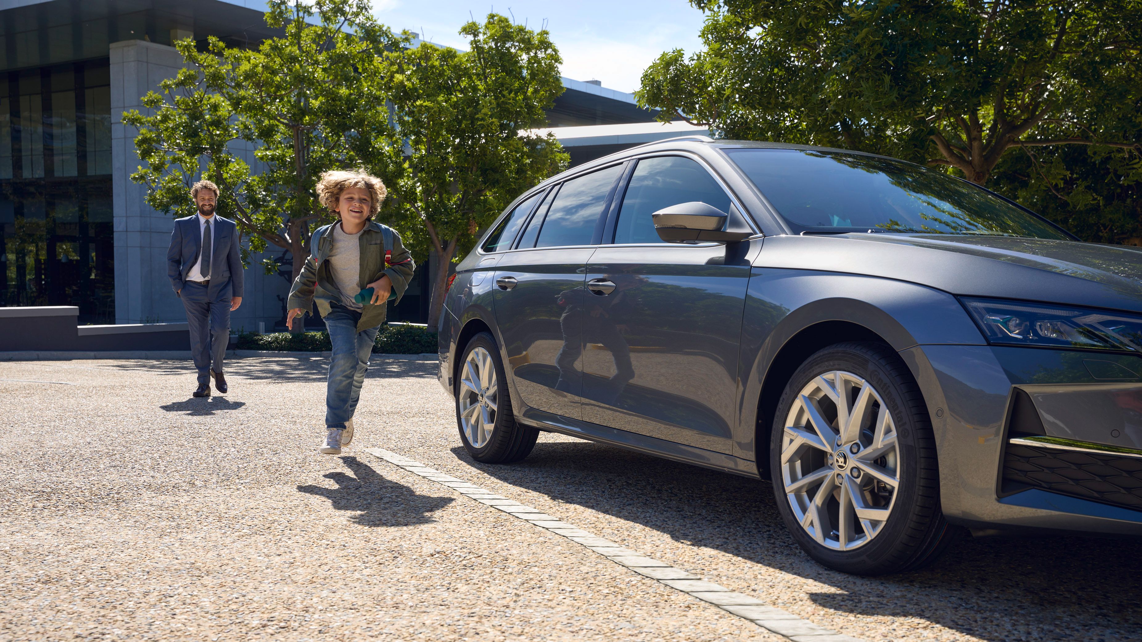 a child running beside a parked Skoda Octavia FL