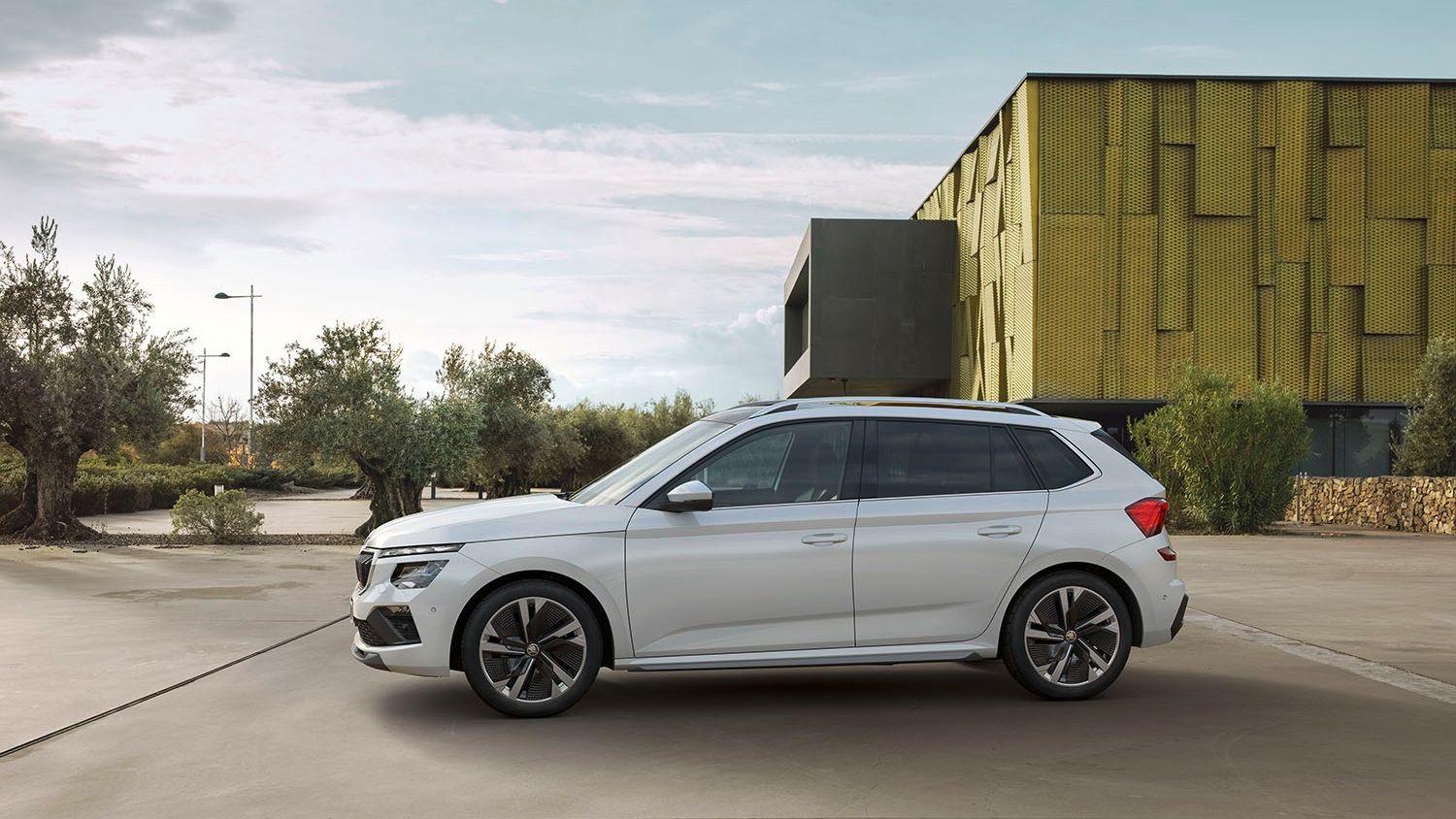 A side profile of the Skoda Kamiq in white parked in a parking lot