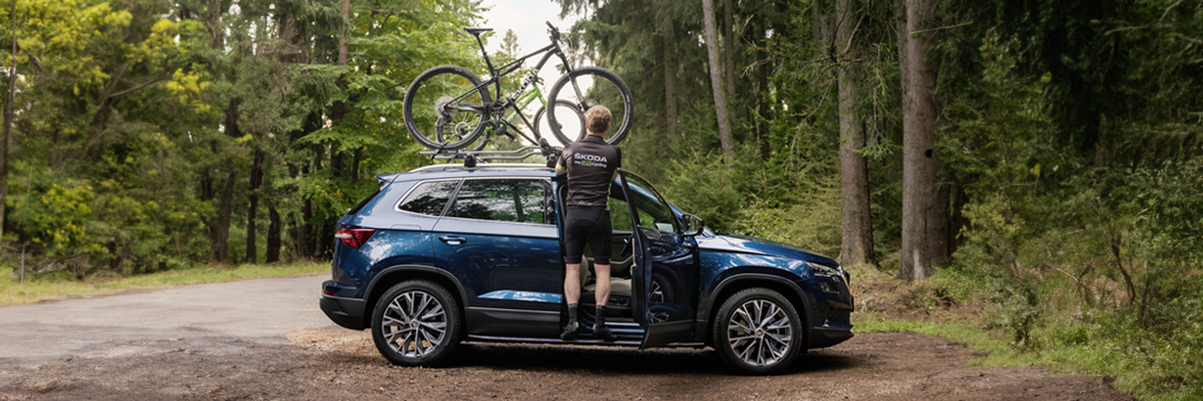 A guy mounting his bike on a Skoda car